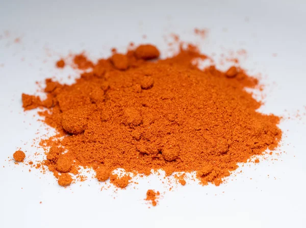 stock image Close-up of red paprika powder on a white surface. Paprika as a spice for cooking.