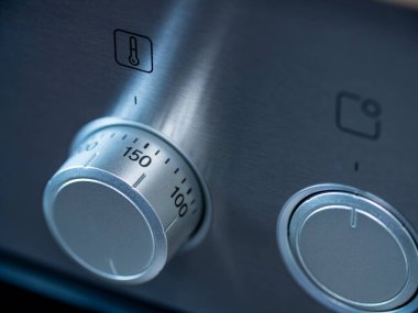 Mutfak fırını, ısıyı ayarlamak için yakın çekim dönüş anahtarı. Paslanmaz çelikten fırın.