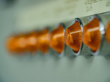 Bir sıra turuncu kontrol lambası olan yakın çekim santrali. Fabrikada elektrik santrali