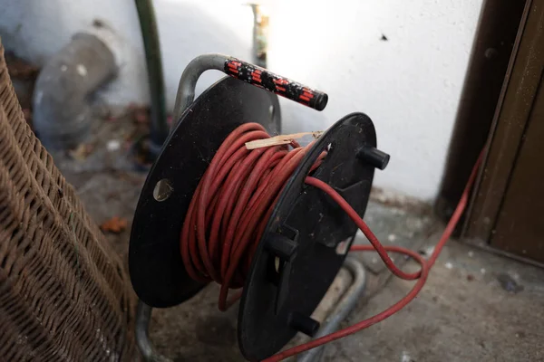 Zwinięty Czerwony Przedłużacz Dla Elektryczności Kołowrotek Kablowy Ogrodzie Zasilania Urządzeń — Zdjęcie stockowe