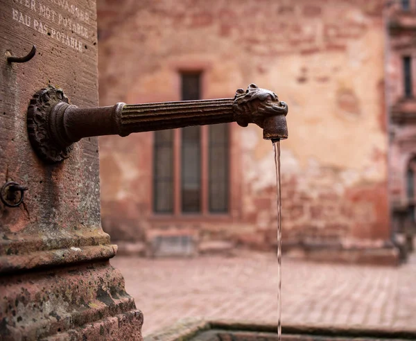 錆びたパイプから水が流れる古い歴史的な井戸 城の古い歴史的井戸 — ストック写真