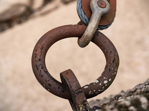 Rusty metal ring holds a wire rope clip. The metal ring holds the wire rope clip with the rope  to fix a pontoon on a river.