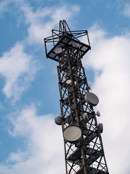 Radio tower with blue sky and some clouds. Radio tower for communication. Transmitting signals for radio, TV, mobile devices, 5G communication.