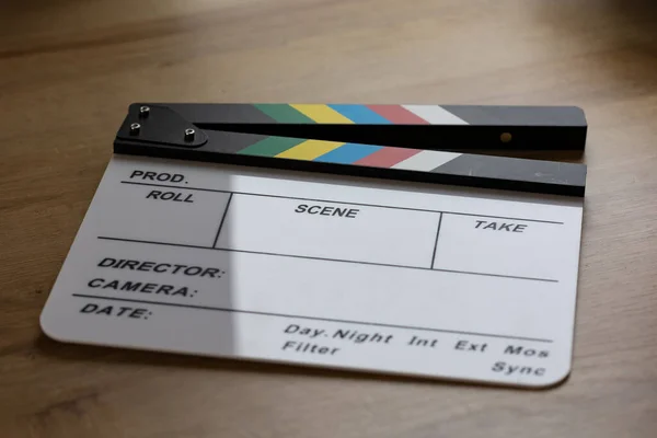 Slate or clapperboard on the table. Clapperboard to show information about the movie, scene, take, director, camera, day or night scene, internal or external scene. Film production and equipment on set.
