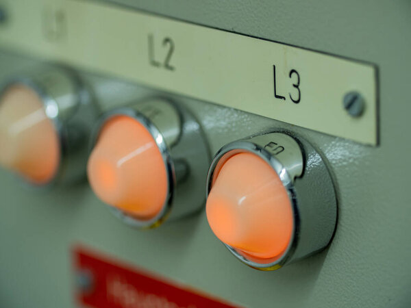 Close-up orange lights on a electricity switchboard. Electrical switchboard in factory