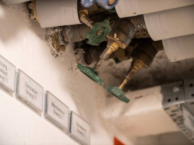 Gaz ve su için izole edilmiş borular. Tavanda yeşil vanalı. Gaz ve su kaynağı.