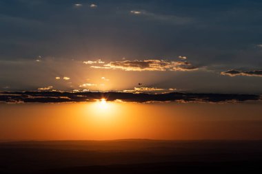 Feldberg 'in Hessen, Almanya' daki dağının manzarası. Güneş batarken tepeleri ve bulutları olan geniş bir arazi..