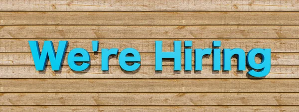 We\'re hiring. Recruitment, career and job sign. Text in blue  against a wooden wall. Business, job offering and Information concepts. 3D illustration