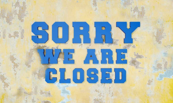 Sorry we are closed. 3D letters in blue on a bright brick wall. Framed by some Let\'s Talk in beige color in small letters.