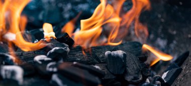 Ateş, ızgarada bir kor kömür. Parlayan kömür ve sıcak közlere yakın çekim. Yaz boyunca barbekü zamanı. Sıcaklık, sıcaklık, barbekü zamanı.