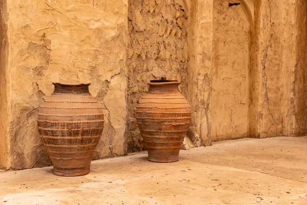 stock image Dubai, Al Fahidi, April 2023 - Old historic district. Two Arabic clay jars in front of a weathered wall.