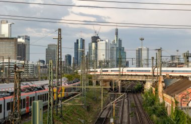 Frankfurt Almanya tren ve silueti - 19 Temmuz 2023: ICE treni şehirden ayrılıyor. Sinyal sistemleri, demiryolu bağlantıları ve şalterleri. Arka planda Frankfurt 'un silüeti.