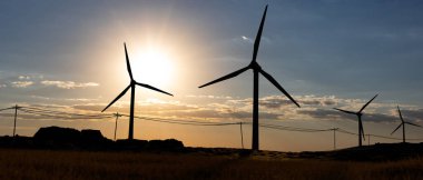 Manzaradaki rüzgar türbinlerinin silueti. Gün batımında bulutlu gökyüzü. Yenilenebilir ve sürdürülebilir enerji, iklim değişikliği, teknoloji. 3B illüstrasyon