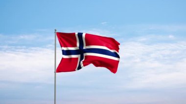 Bulutlu gökyüzüne karşı Norveç bayrağı. Norveç bayrağı rüzgarda sallanıyor, ulusal bir sembol. Ülke, ulus, birlik, bayrak, hükümet, Norveç kültürü, siyaset.
