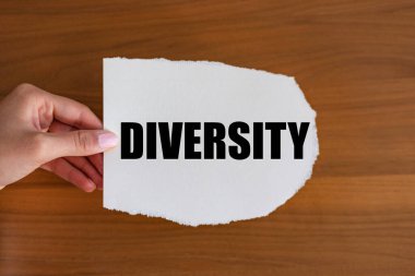 Diversity. Woman hand holds a piece of paper with a note, diversity. Variety, different, contrast, anomaly. clipart