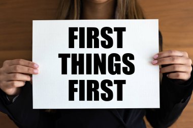 First things first. Woman with white page, black letters. Prime, strategy, important, on top of the list. clipart