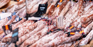 Satış vitrininde kurumuş salamlar, Rotterdam 'da market tezgahı, Bram Ladage Markthal. Tütsülenmiş sosis, et, lezzetli.