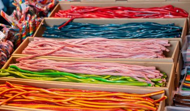 Renkli ve uzun şekerli şeker yılanları. Şeker, meyve aromalı ve diğer malzemelerden yapılan lezzetli tatlılar.. 