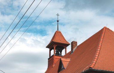 Tepesinde haç olan kilise kulesi ve Dessau, Saksonya-Anhalt, Almanya 'da çan kulesi. Yanında da elektrik kabloları var. Din, Hristiyanlık, ibadet yeri, dua, inanç. 