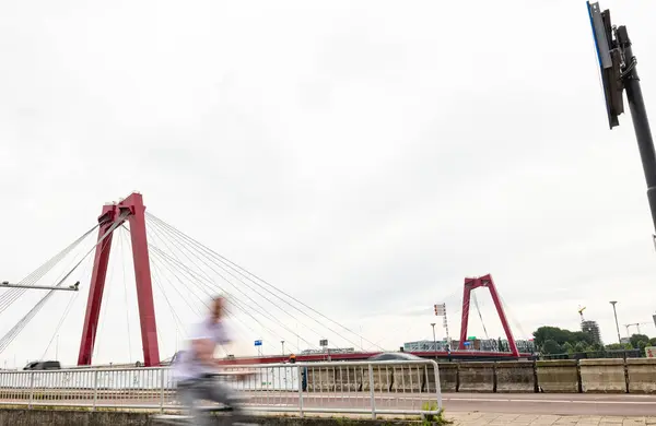 stock image Willems bridge in Rotterdam, spanning the Nieuwe Maas. Blurred person in the foreground. Cloudy day at  the afternoon.