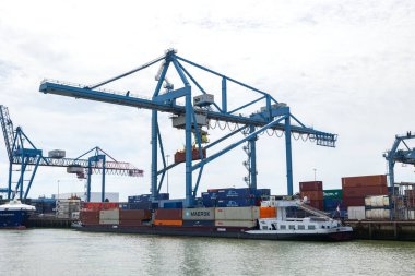 Rotterdam Hollanda - 9 Temmuz 2024: Rotterdam kargo ve sanayi limanında kargo terminali. İki vinç yükleme ve boşaltma iki konteyner gemi çeşitli konteynırlar rıhtıma kenetlenmiş. 