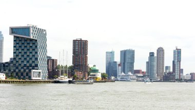 Rotterdam Hollanda - 9 Temmuz 2024: Rotterdam 'ın şehir ve modern mimarisi. Nieuwe Maas 'ın deniz tarafından bak. Turistler için bir yolcu gemisi gemi terminaline demir atmıştır..