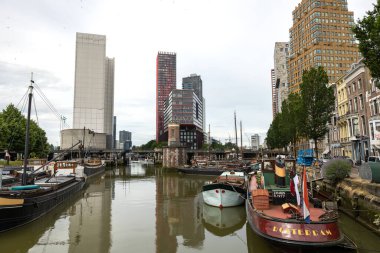 Rotterdam Hollanda - 9 Temmuz 2024: Rotterdam Oudehaven rıhtımında bulunan tekneler. Ofis binaları bu civarda. Karanlık suda bazı yansımalar var.. 