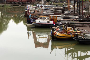 Rotterdam Hollanda - 9 Temmuz 2024: Rotterdam Haringvliet rıhtımında yatan bazı tekneler. Bulanık suda yansımalar. 
