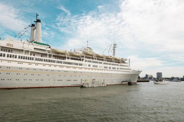 Rotterdam Hollanda - 9 Temmuz 2024: Güneşli bir günde eski yolcu gemisi Rotterdam. Yolcu gemisi 1959 'da inşa edildi ve limana yanaştı. Günümüzde turistler için müze ve otel olarak kullanılmaktadır..
