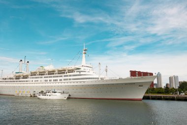 Rotterdam Hollanda - 9 Temmuz 2024: Güneşli bir günde eski yolcu gemisi Rotterdam. Yolcu gemisi 1959 'da inşa edildi ve limana yanaştı. Günümüzde turistler için müze ve otel olarak kullanılmaktadır..