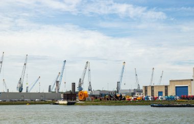 Rotterdam, Hollanda - 9 Temmuz 2004: Towqars depolarını, nakliyeye hazır nakliye vinçlerini ve yeni kamyonları görün. Ön planda büyük turuncu kablo makarası var..