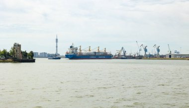 Rotterdam, Hollanda - 9 Temmuz 2004: Rotterdam sanayi limanında kanatlı bir gemi. Arka plandaki vinç ve depoları taşı.