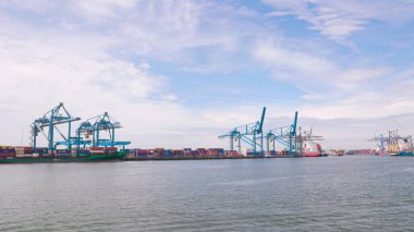 Rotterdam Hollanda - 9 Temmuz 2024: Kargo vinçleri, konteynır ve nakliye gemileriyle Rotterdam limanının panoraması yazın hafif bulutlu bir günde. Uluslararası yük ve mal taşımacılığı.