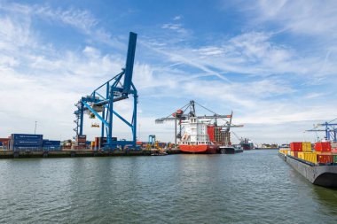 Rotterdam, Hollanda - 9 Temmuz 2004: Ön planda büyük mavi konteyner vinç. Rotterdam limanının arka planında gemiler ve diğer vinçler.