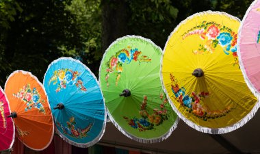 Yeşil, kırmızı, mavi ve sarı renkli Asya güneş şemsiyeleri. Geleneksel el işi, çiçek deseni, güneş gölgesi, sanat ve zanaat, kumaş, şemsiye, renkli .