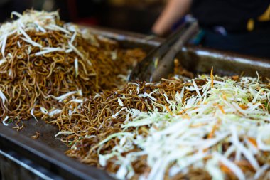 Kentteki bir markette hazırlanmış lahana salatasıyla birlikte kahverengi Asya eriştelerini yakın..