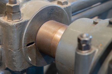 Flanjlı ve vidalı eski boru hattı, pompaya bağlı, arka plana odaklan. Mekanik bağlantı, boru hattı, endüstriyel tasarım, eski makine.