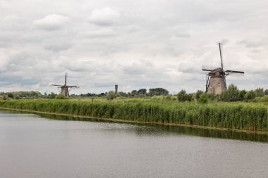 Nehirde iki tarihi rüzgar değirmeni.