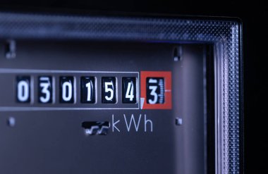 Close-up analog electricity meter. Measuring used electricity in kWh ( kilowatt hour ) clipart