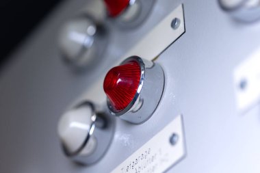 Isıtma sisteminin güç dağıtıcısına beyaz ve kırmızı bir sinyal lambası yakın plan. Analog cihazı, elektrikli ekipman, kontrol paneli teknolojisi.