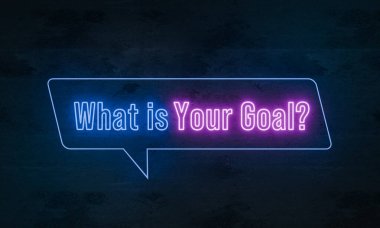 Amacın nedir? Koyu beton bir duvarda mavi ve mor renkli ışıklı neon tabela. Başarı, hedef, görev, plan, vizyon.