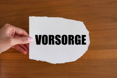 Vorsorge (sağlama, önleyici). Bakım, destek, koruyucu, önsezi. Kadın eli elinde bir notla bir kağıt parçası tutuyor.. 