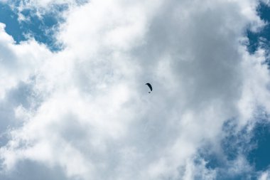 Paraglieder güneşli bir günde gökyüzünde uçar, arka planda bulutlar, İsviçre, İsviçre Alpleri. Ekstrem spor, boş zaman aktiviteleri, güneşli gün, açık hava, manzara.