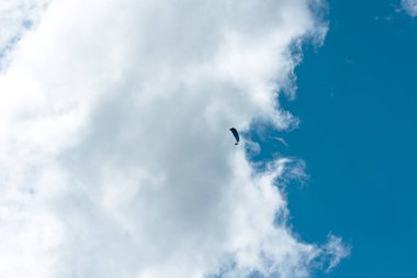 Paraglieder güneşli bir günde gökyüzünde uçar, arka planda bulutlar, İsviçre, İsviçre Alpleri. Ekstrem spor, boş zaman aktiviteleri, güneşli gün, açık hava, manzara.