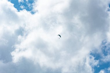 Güneşli bir günde gökyüzünde paraşütçü, bulutlar, İsviçre, İsviçre Alpleri. Ekstrem spor, boş zaman aktiviteleri, güneşli gün, açık hava, manzara.