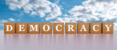 Demokrasi. Beyaz büyük harfli tahtadan zarlar ve demokrasi. Arkada bulutlu bir gökyüzü var. Cumhuriyet, egemenlik, konuşma özgürlüğü, kendi kaderini tayin, insan hakları, koruma, referandum. 3B illüstrasyon