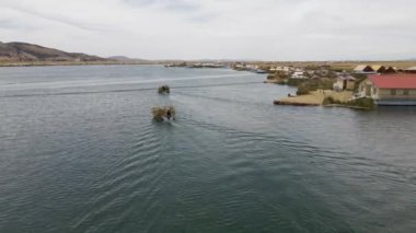 4K Hava Aracı, Titicaca Gölü, Puno, Peru 'daki Uros Adaları' nda sazlık taşıyan üç tekneyi takip ediyor. Otantik Tekne, Göl, Sazlıklar, Yüzen Adalar görünür
