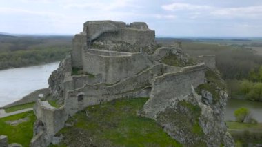 4K Hava Aracı mazgallı antik şatonun üzerinde uçuyor. Arka planda nehir var. Slovakya, Bratislava yakınlarındaki Devin Kalesi