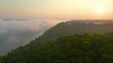 Kentucky 'deki Foggy Ohio Nehri ve Trees üzerinde 4K Hava / İnsansız Hava Aracı yükseliyor. Gün doğumu görünüyor. Uzaktan görülebilir çiftlikler