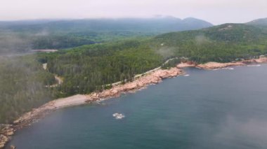 4K Hava Aracı, Çam Ağacı Yarımadası 'nın üzerindeki bulutların arasından geçiyor. Su, Ağaçlar, Kayalar, Kıyı görünür